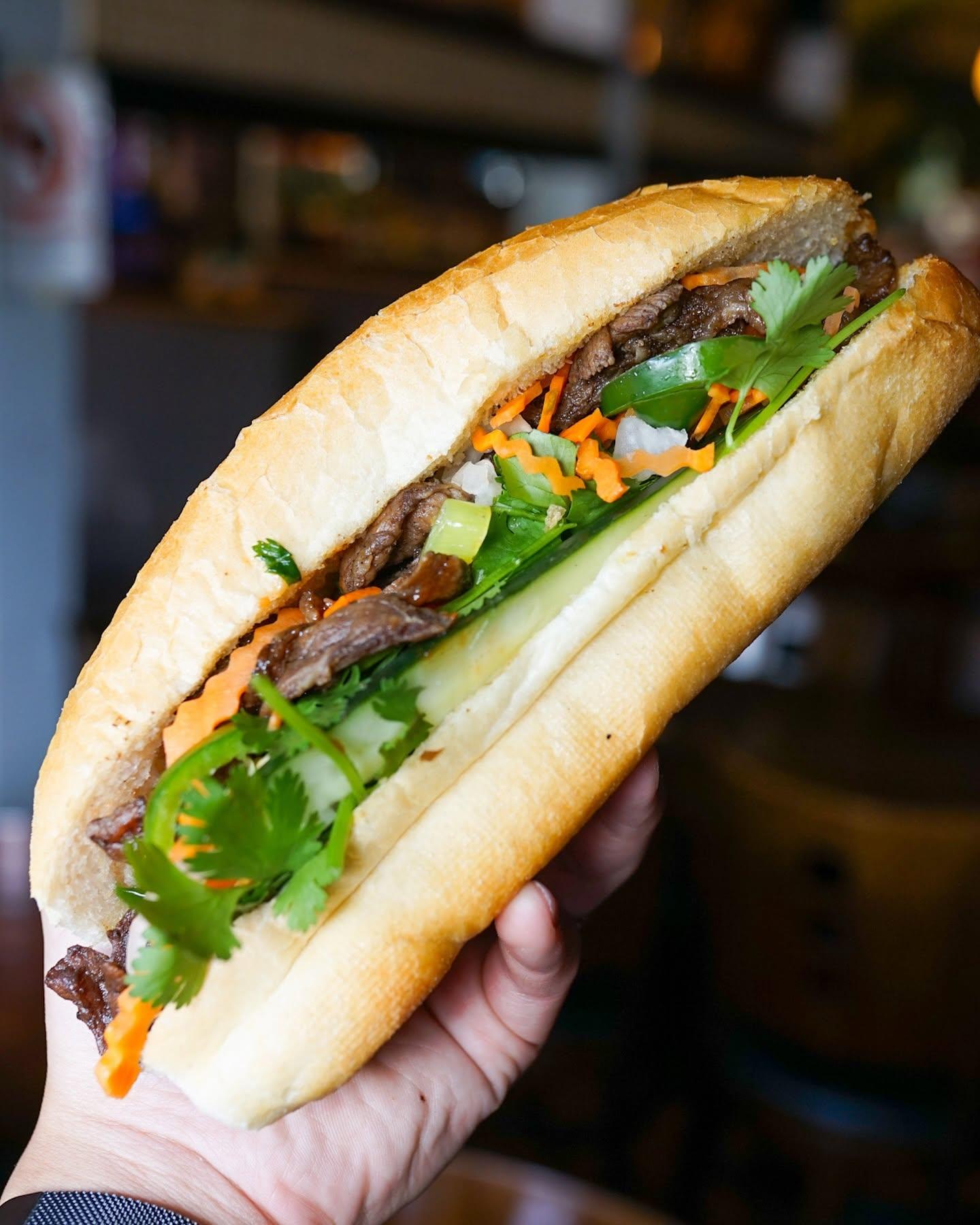 Grilled beef banh mi with pickled carrots, cucumber, jalapeño, and cilantro