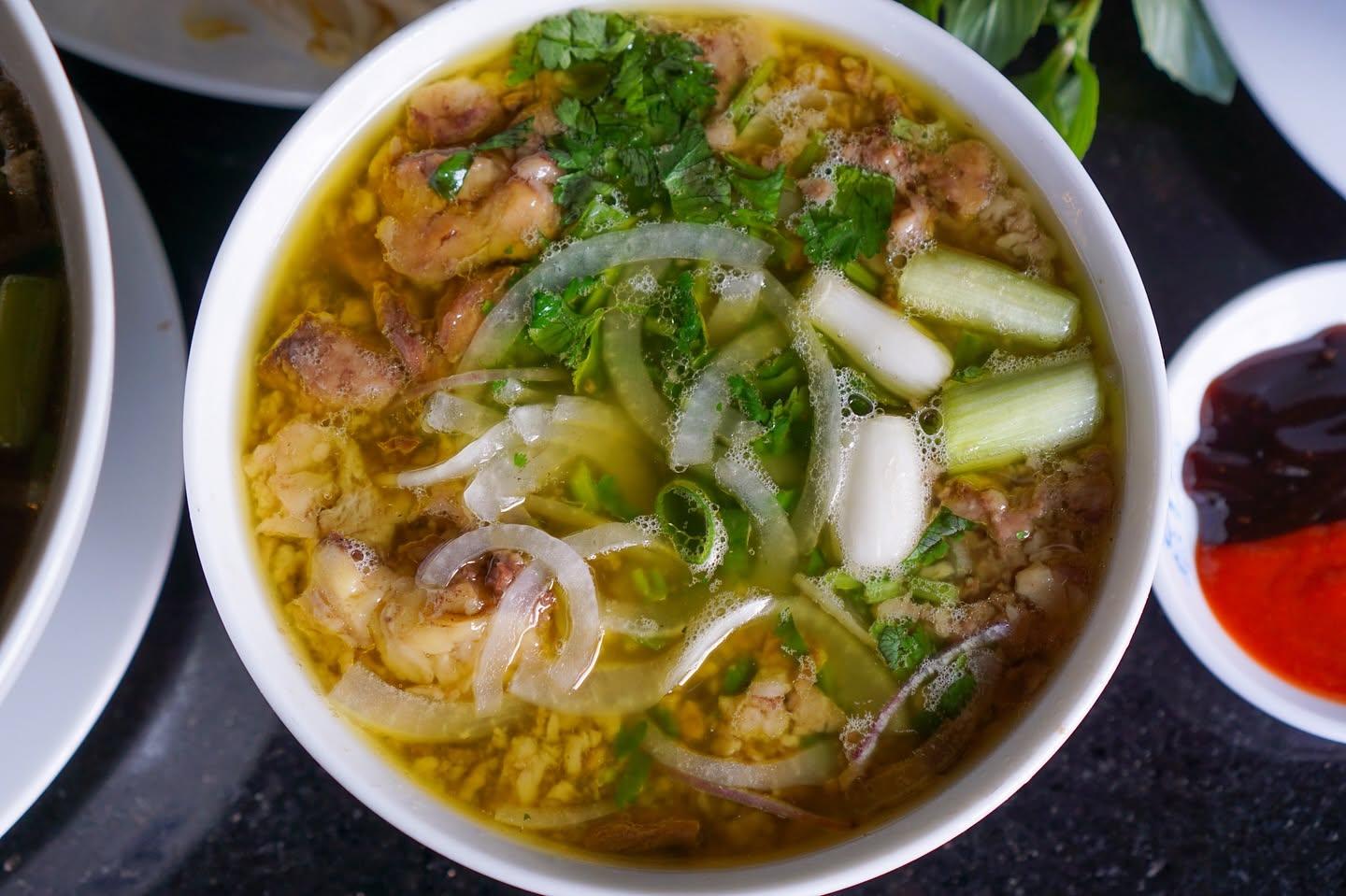 Chicken pho with golden broth, onions, and fresh herbs